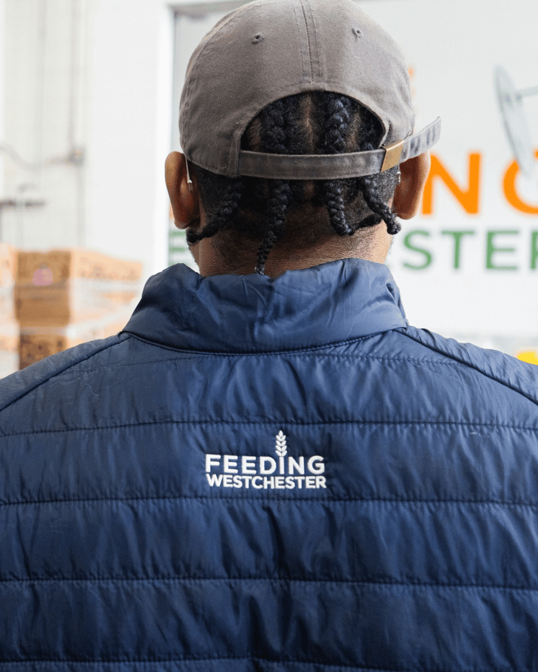 Back view of a Feeding Westchester team member wearing a branded jacket at the distribution center